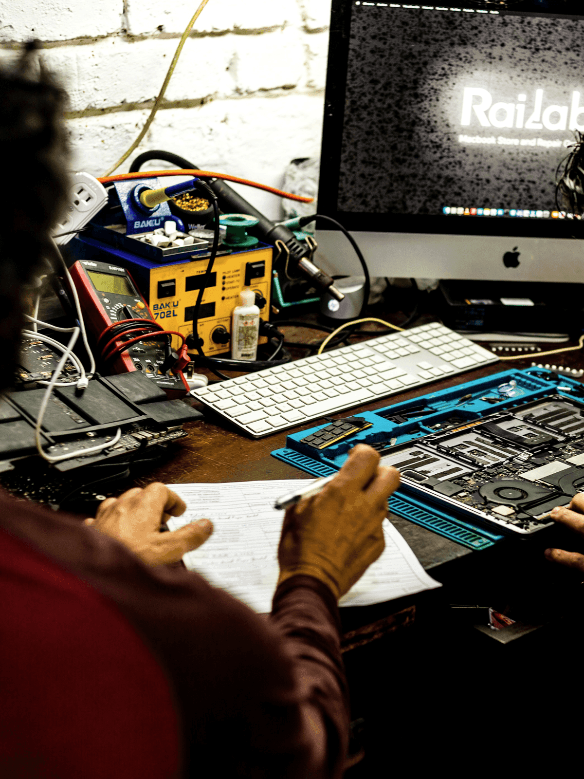 Technicians repairing a computer motherboard